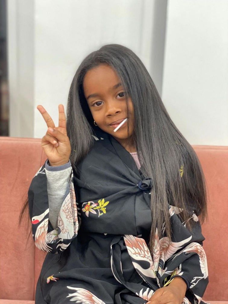 Jeune fille aux longs cheveux raides, faisant le signe de la paix,