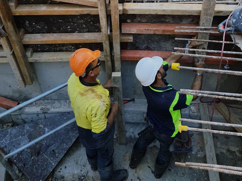 two concrete workers checking structure