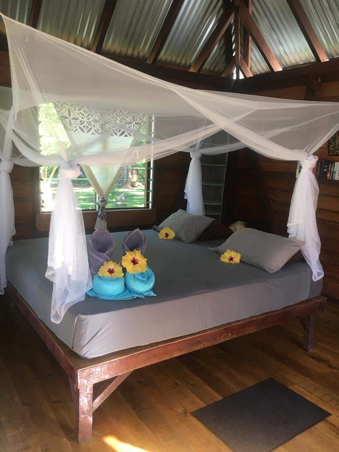 A comfortable looking bed under a mosquito net in a beachfront cottage at Viani Bay Resort on Rainbow reef in Fiji 