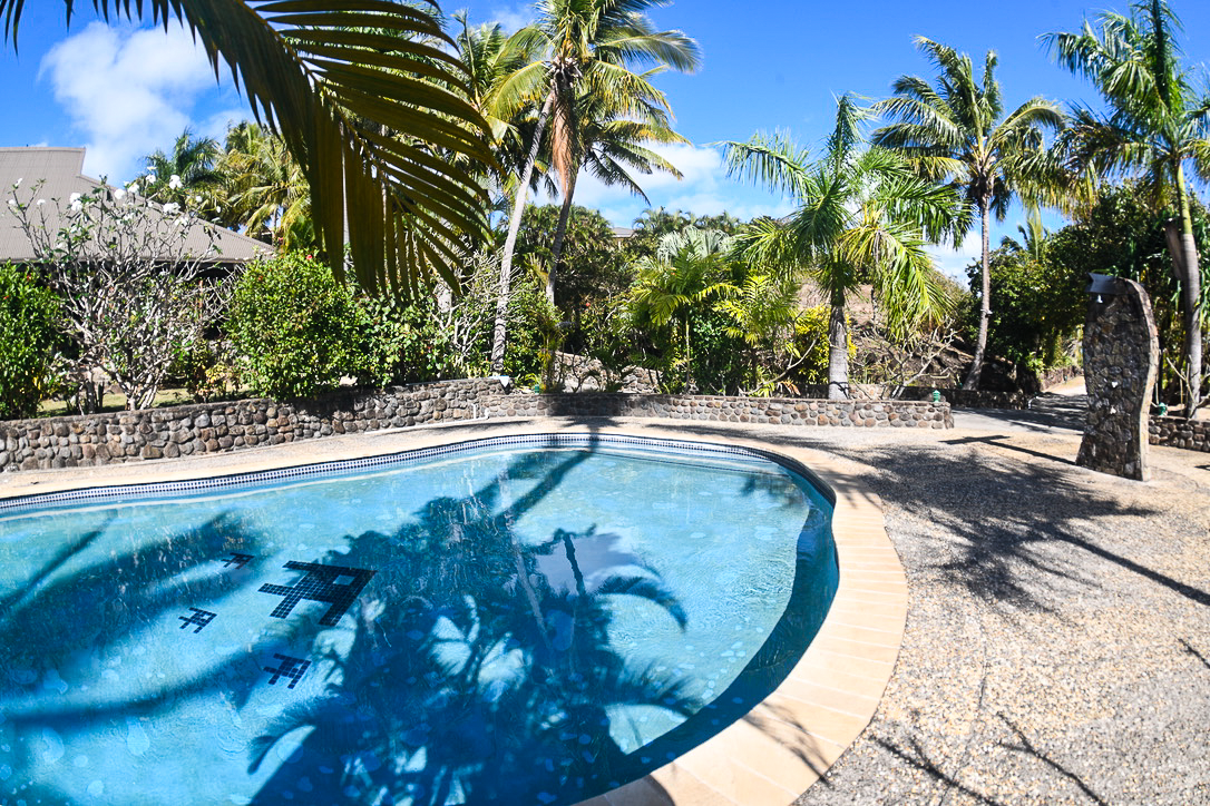 Palm trees reflect shadows over the pool at Volivoli Beach Resort 