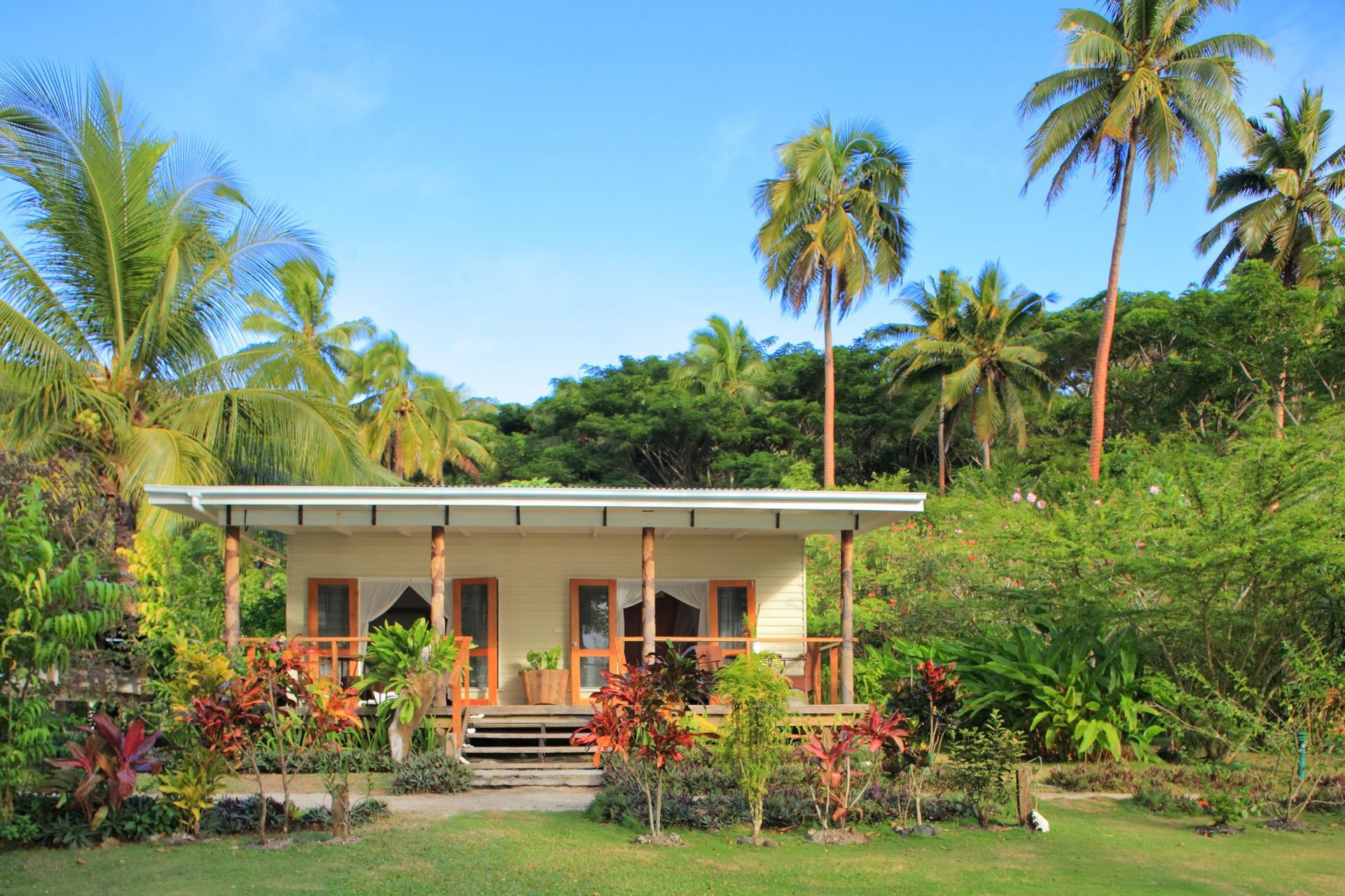 The surrounding verdant gardens and coconut trees around the deluxe beach front villa at Sau Bay Resort in Fiji 