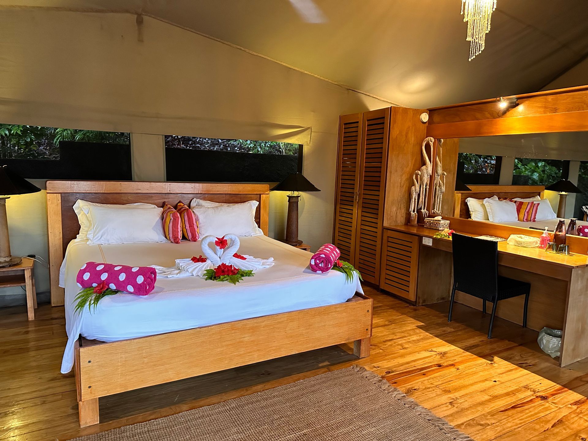 A double bed decorated in Fijian flowers and towels at Sau Bay resort in Fiji 