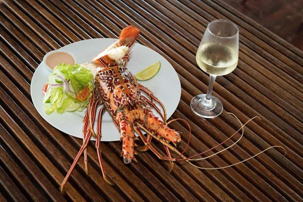 A lobster dinner accompanied with a glass of chilled white wine - part of the delicious all inclusive meal plan at Volivoli Beach Resort, Fiji