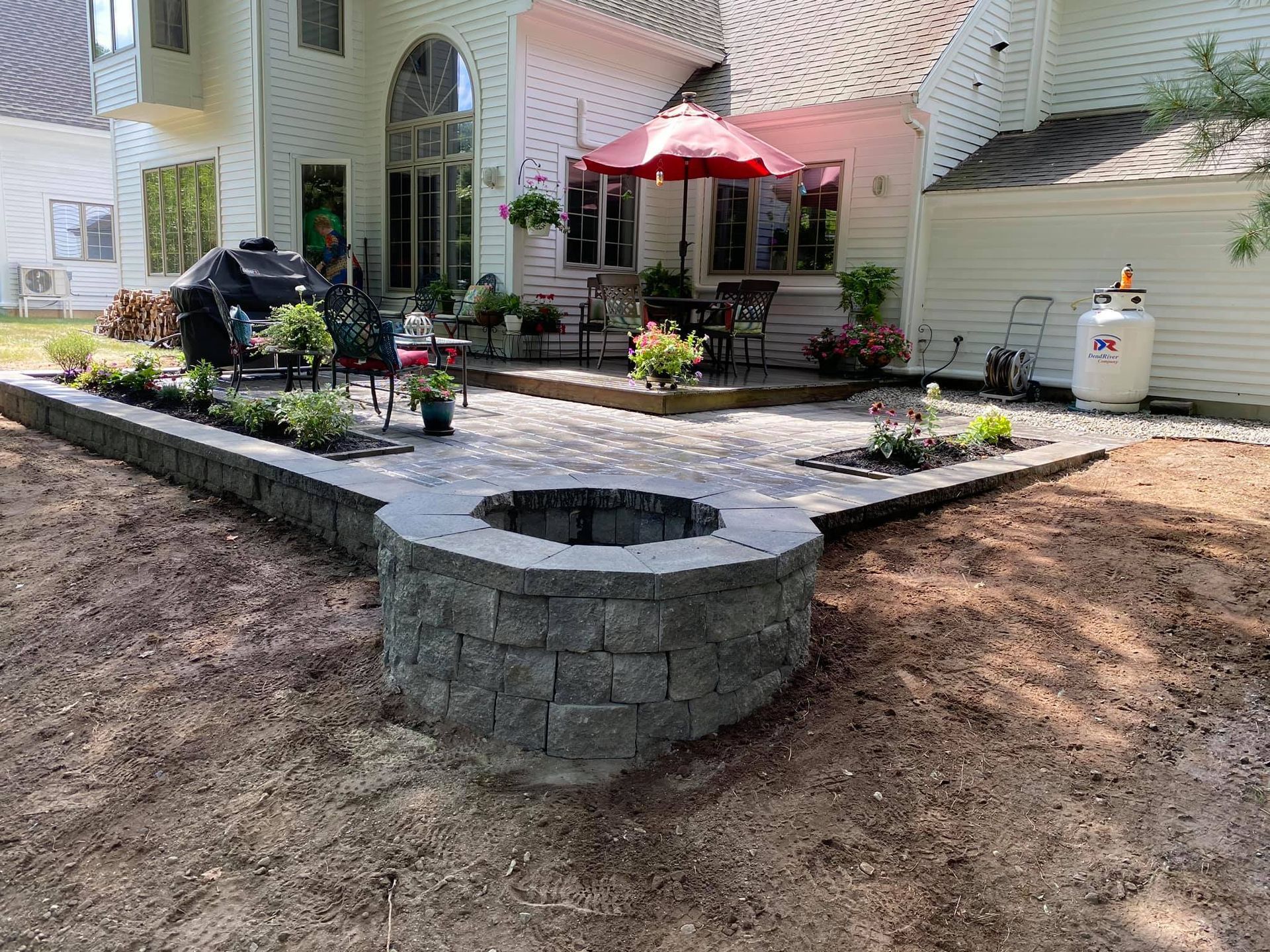 Backyard patio with a fire pit and outdoor seating.