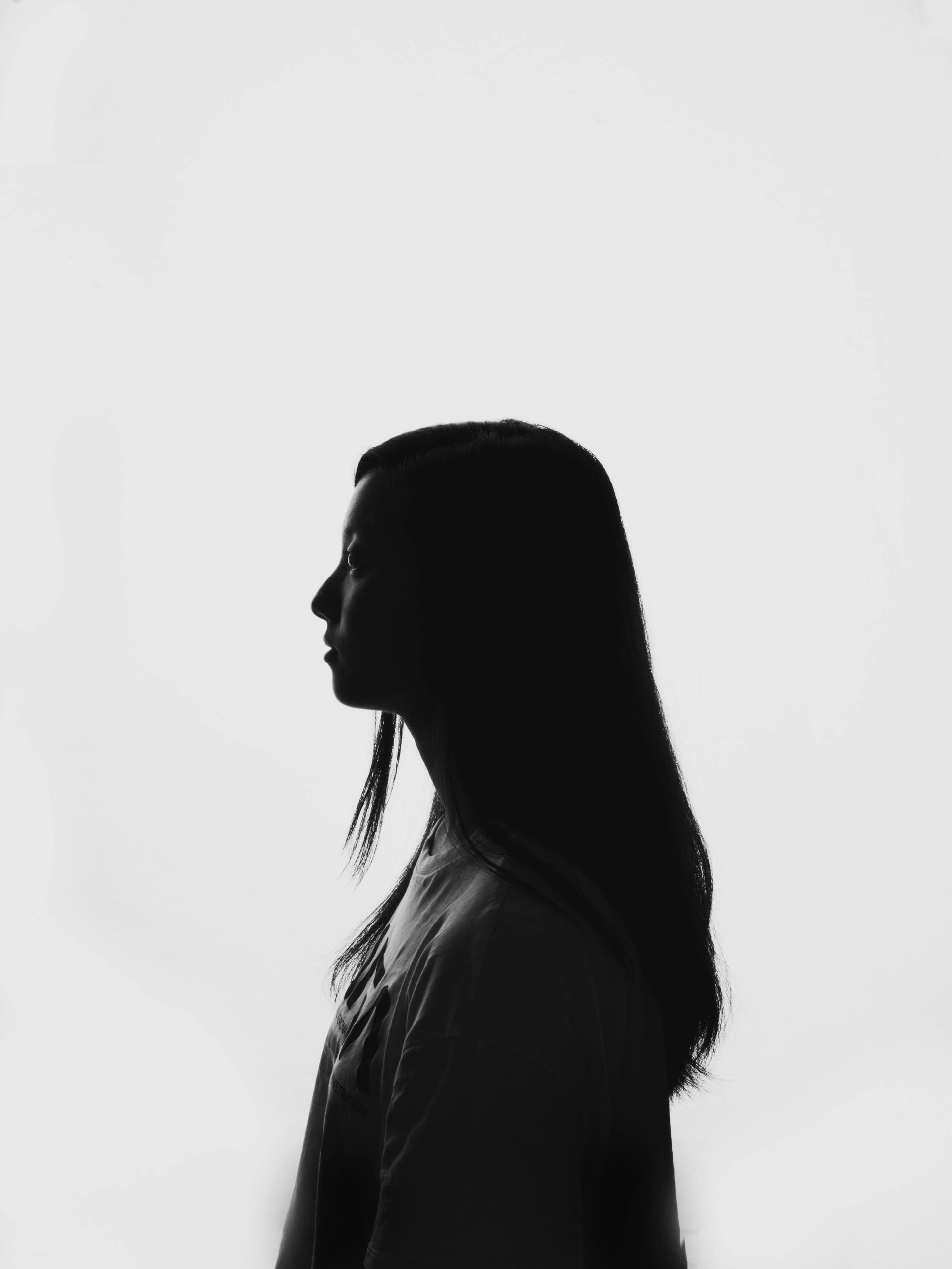 A silhouette of a woman with long hair against a white background