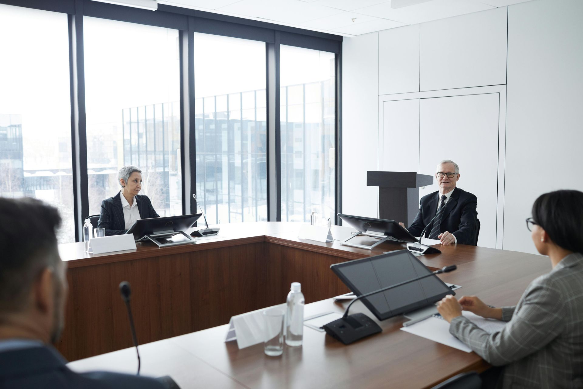 A group of people are sitting at a table in a conference room.