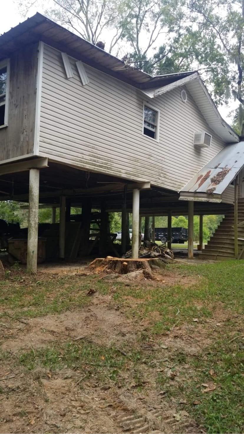 A house on stilts with a picnic table in front of it.