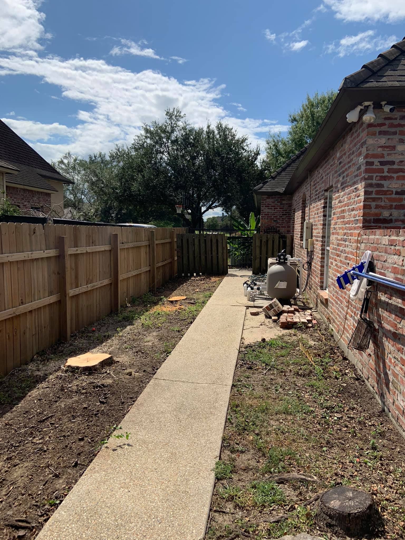 A brick house with a wooden fence and a walkway leading to it.