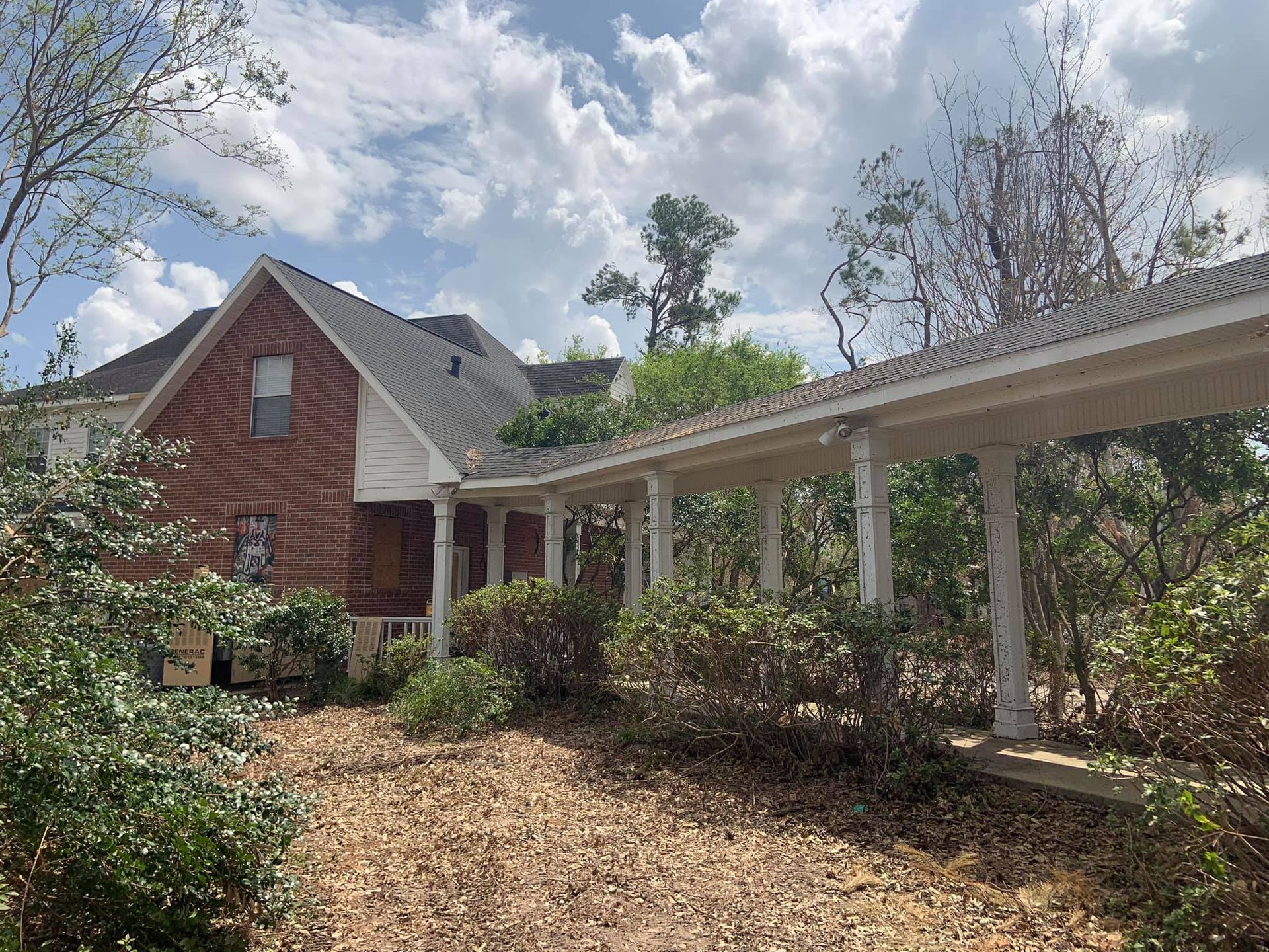 A brick house with a porch and a walkway leading to it.