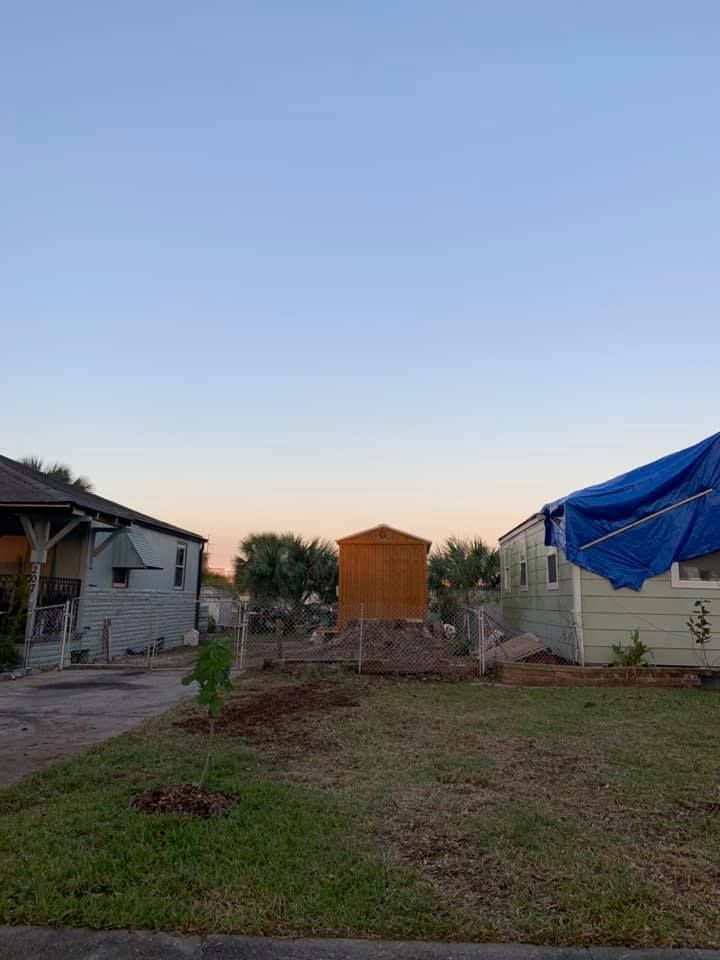 A blue tarp is covering a house in a residential area.
