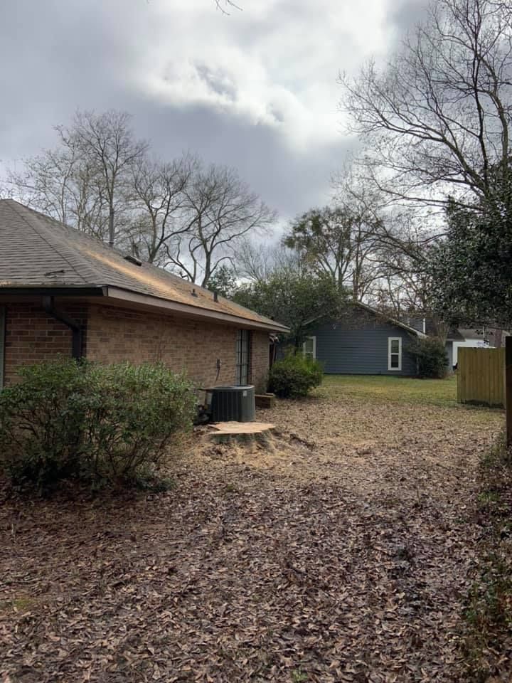 The backyard of a house with a picnic table in the middle of it.