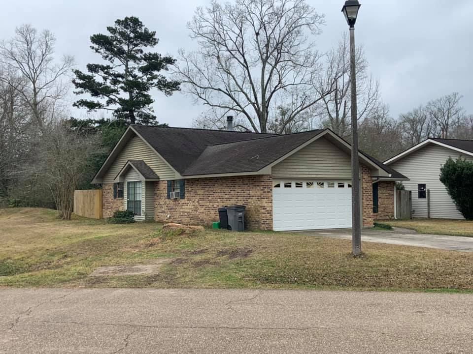 A house with a garage and a street light in front of it