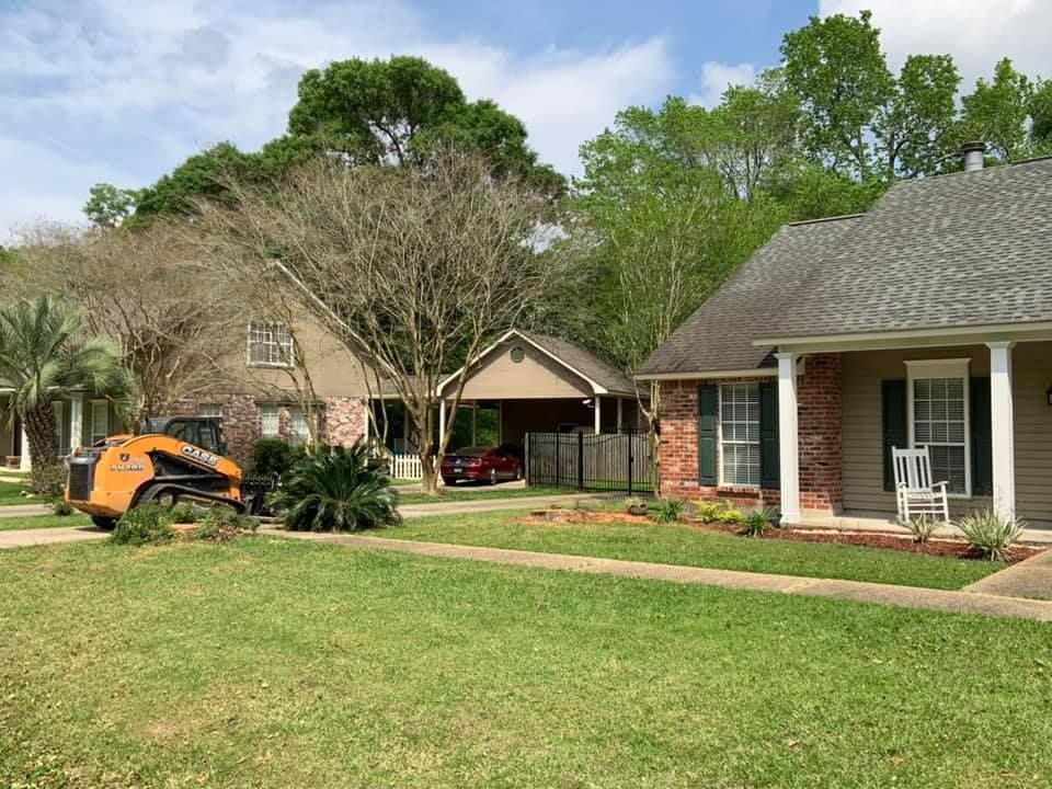 A house with a tractor parked in front of it.