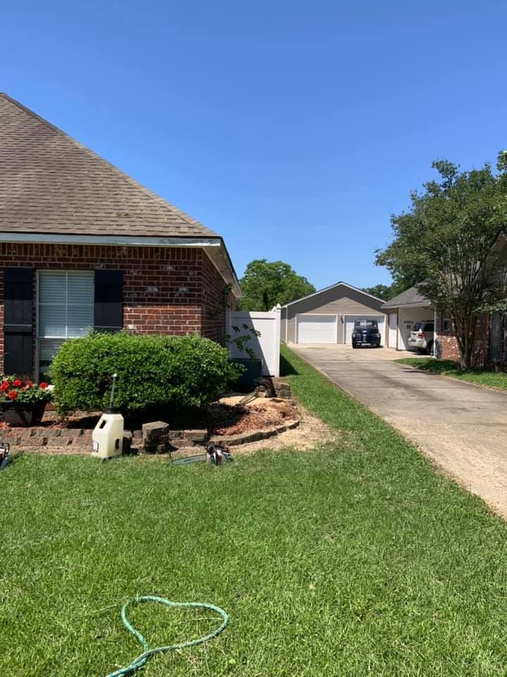 A house with a hose in front of it and a driveway leading to it.