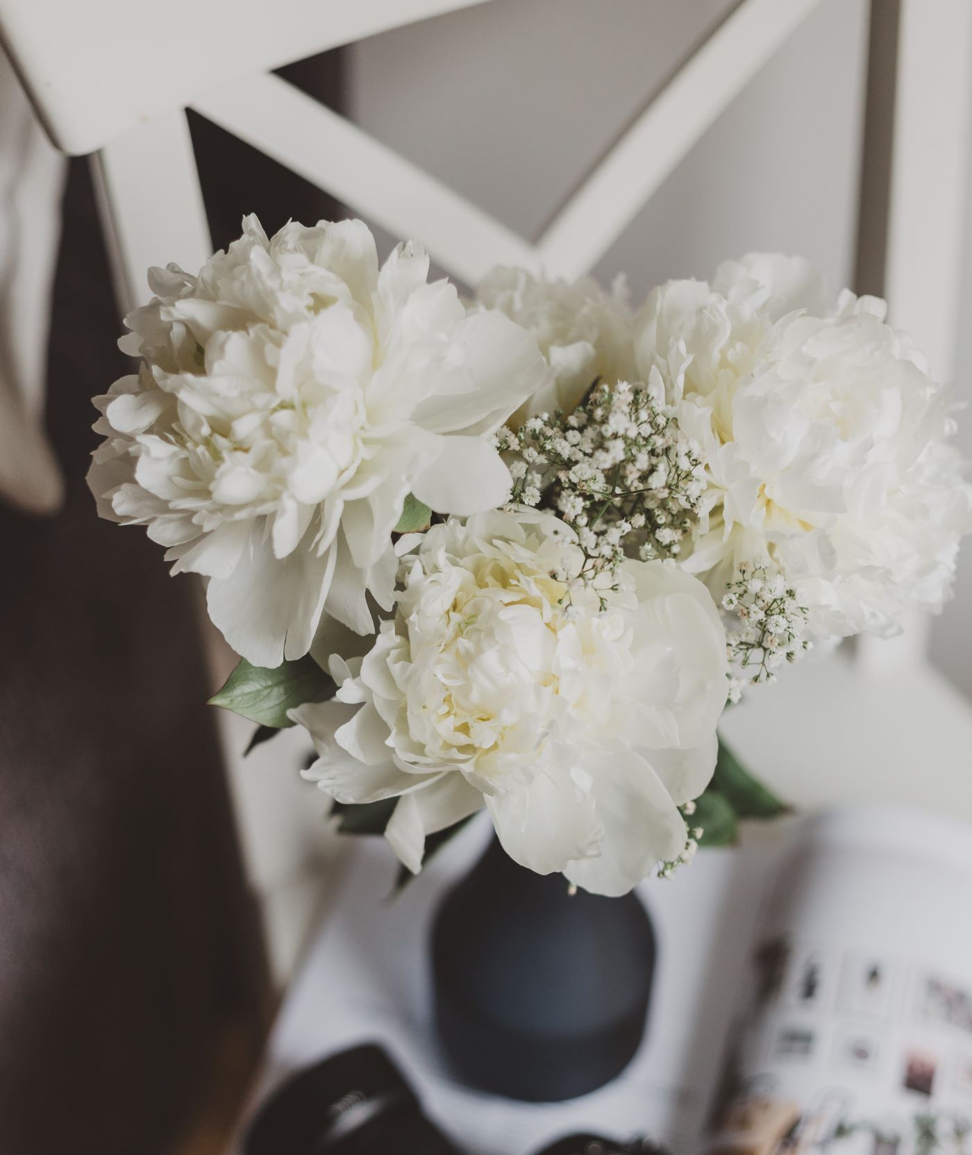 White flowers in a black vase on a table