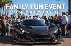 A black sports car on display at a family fun event with a large crowd; spectators are free.