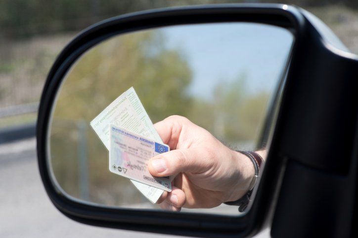 A man shows driver's license and registration during a check
