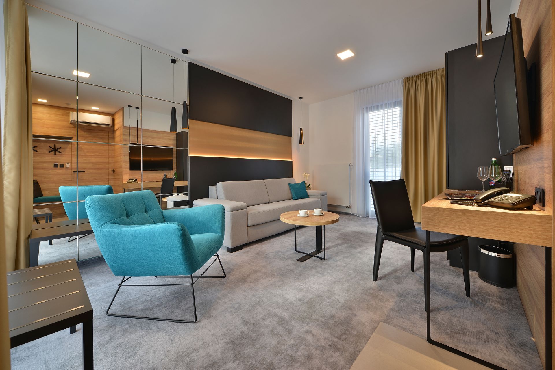 Obývací pokoj s pohovkou, židlemi, stoly a televizí.