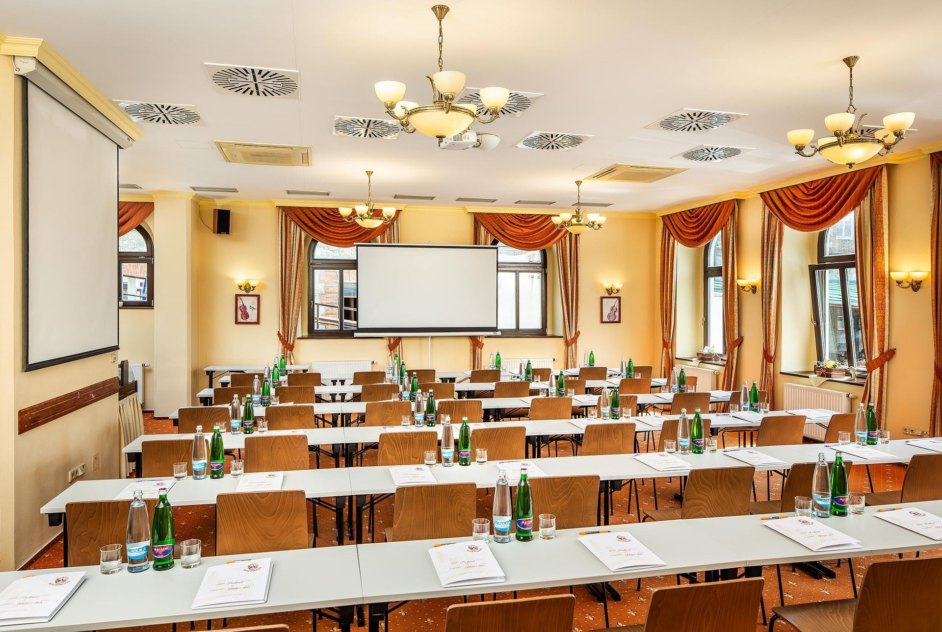 Hlediště s řadami sedadel a promítacím plátnem