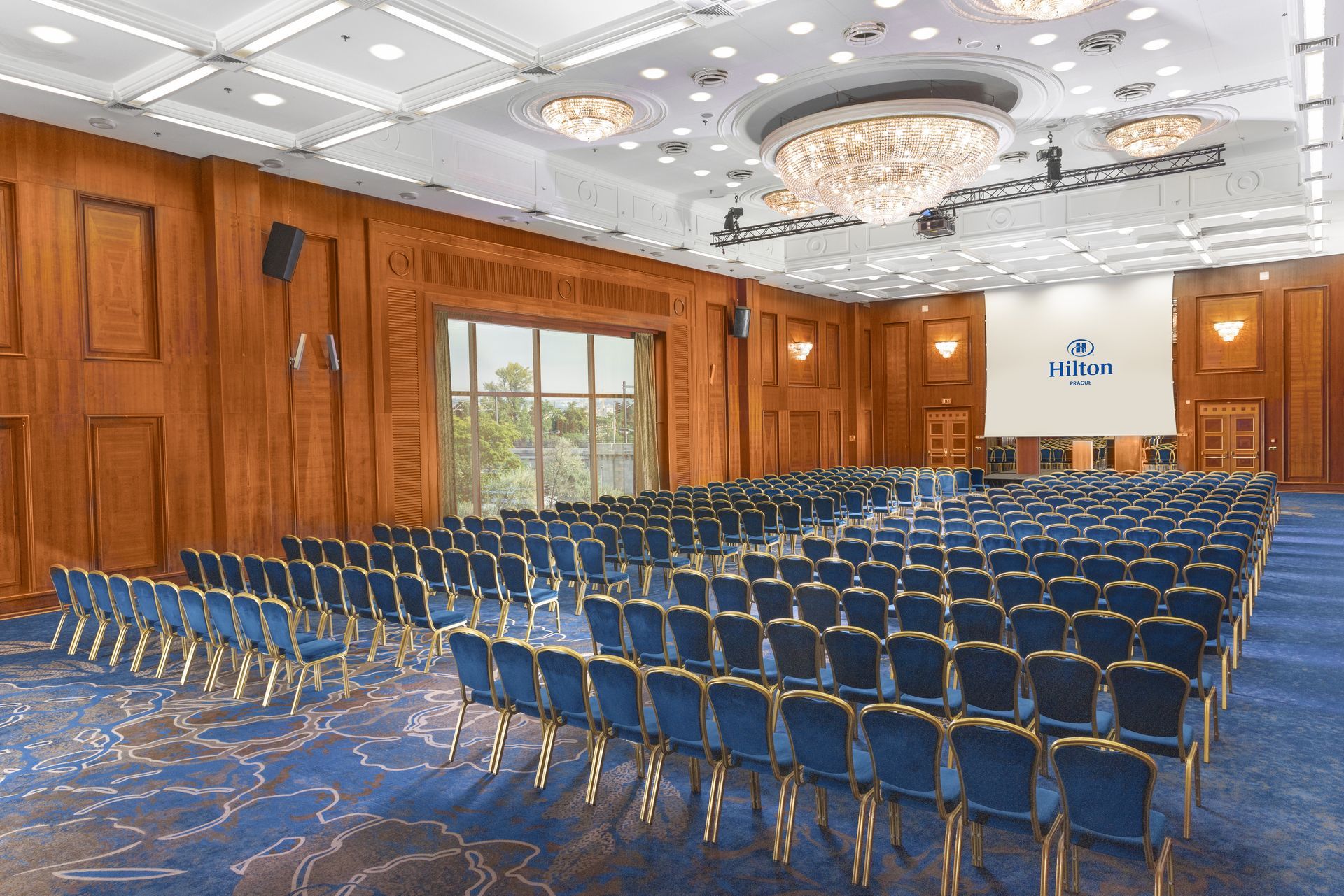 Velká konferenční místnost s řadami černých židlí