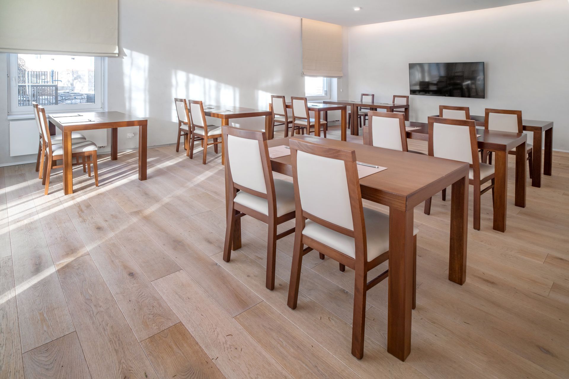 V této místnosti je mnoho stolů a židlí.