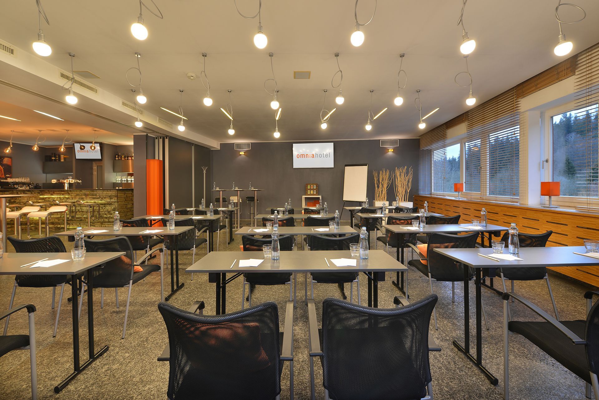 Velká místnost se stoly a židlemi připravenými pro konferenci.