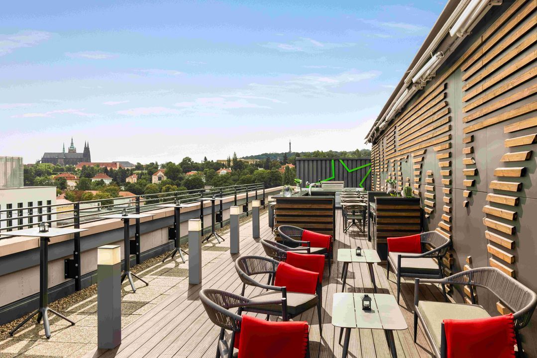 Velká konferenční místnost se stoly a židlemi a projektorem.