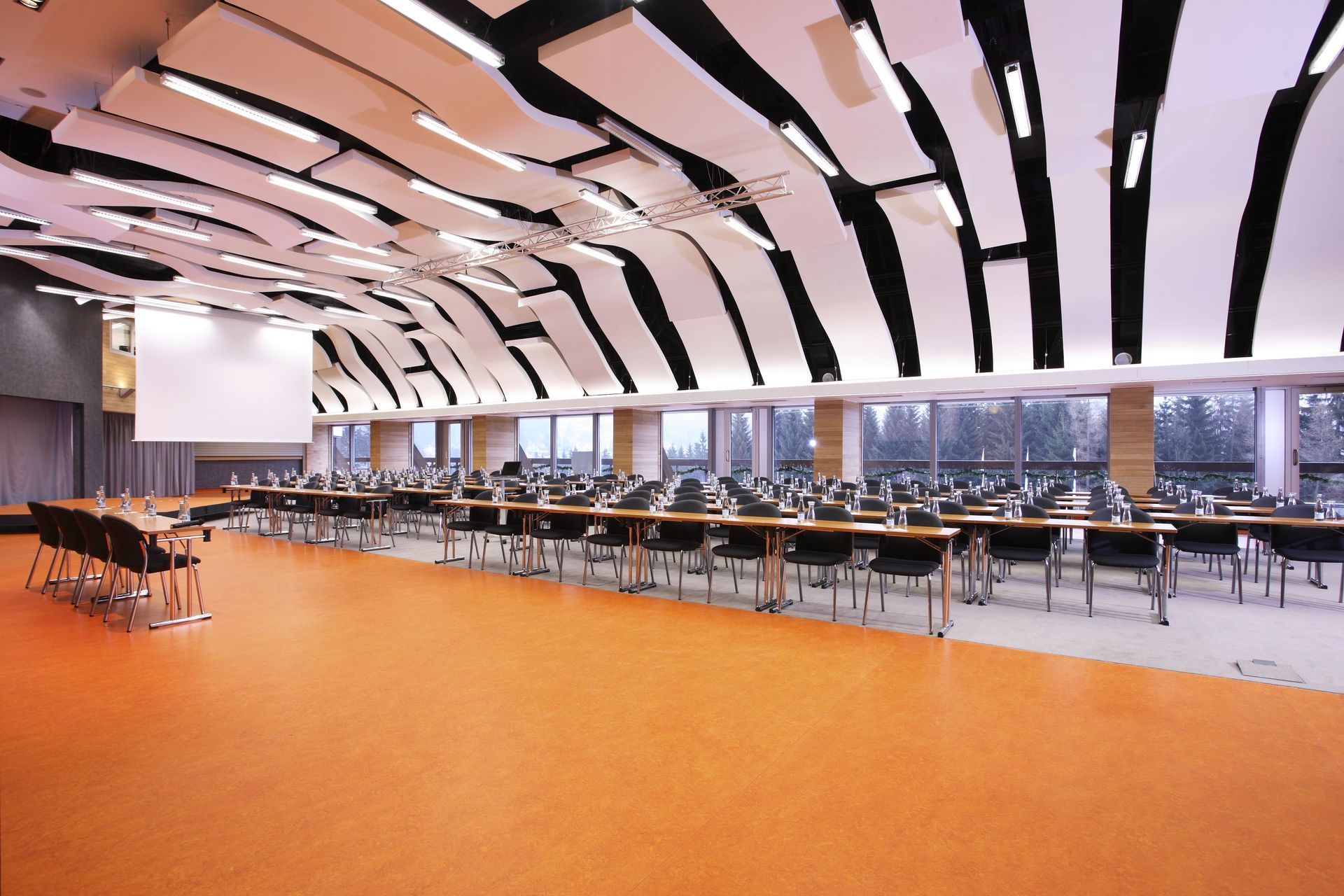 Velká místnost se stoly a židlemi a stropem s potiskem zebry