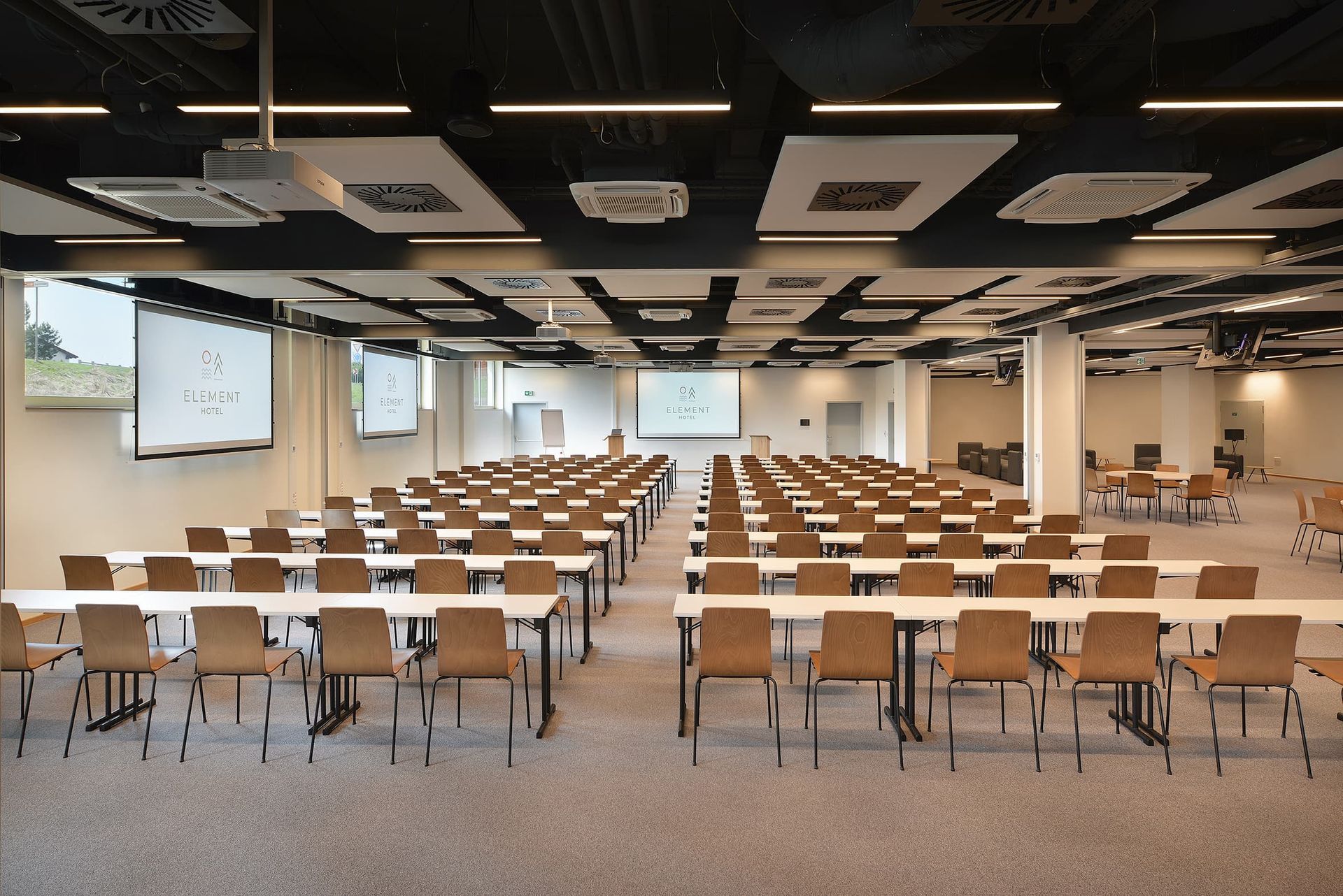 Velká místnost s řadami stolů a židlí