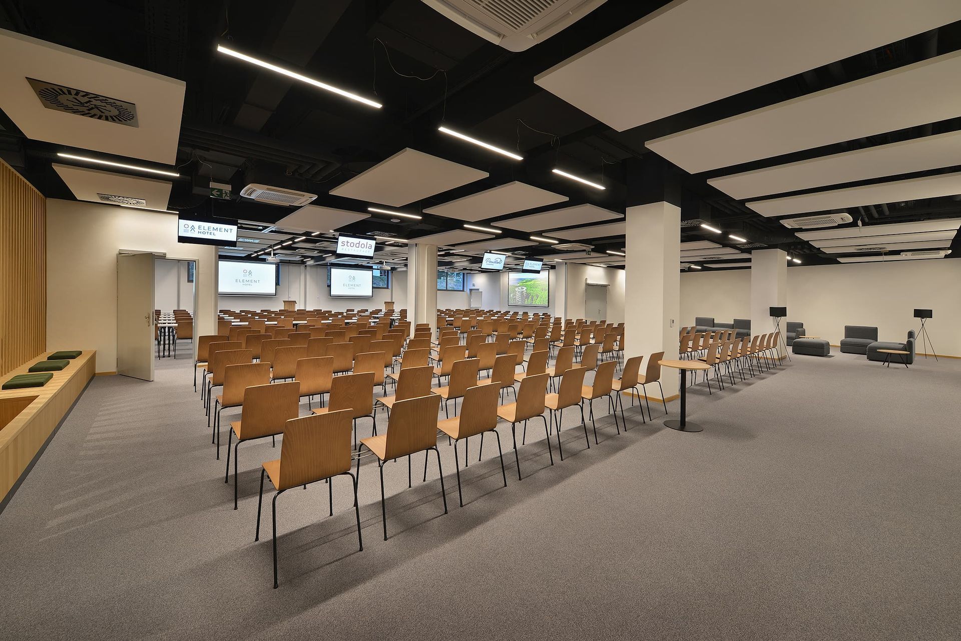 Velká konferenční místnost s řadami židlí a stolů.