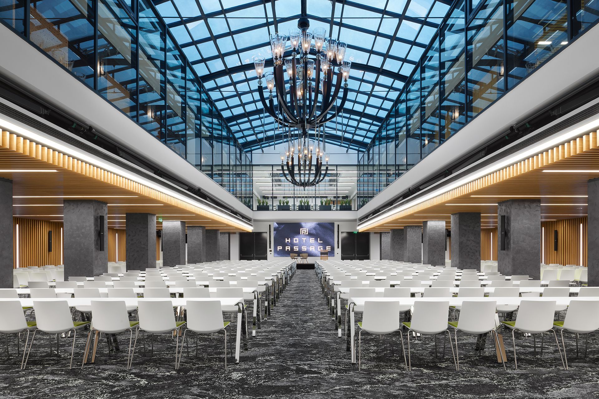 Velká konferenční místnost se stoly a židlemi a lustrem.