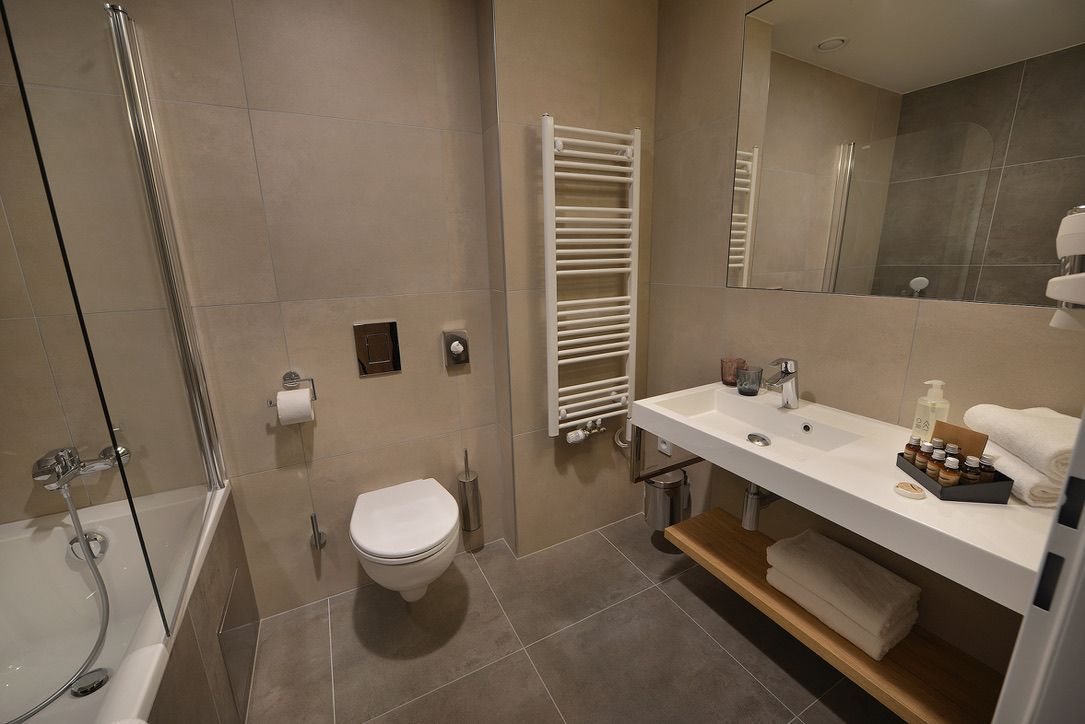 Koupelna s toaletou, umyvadlem a vanou.