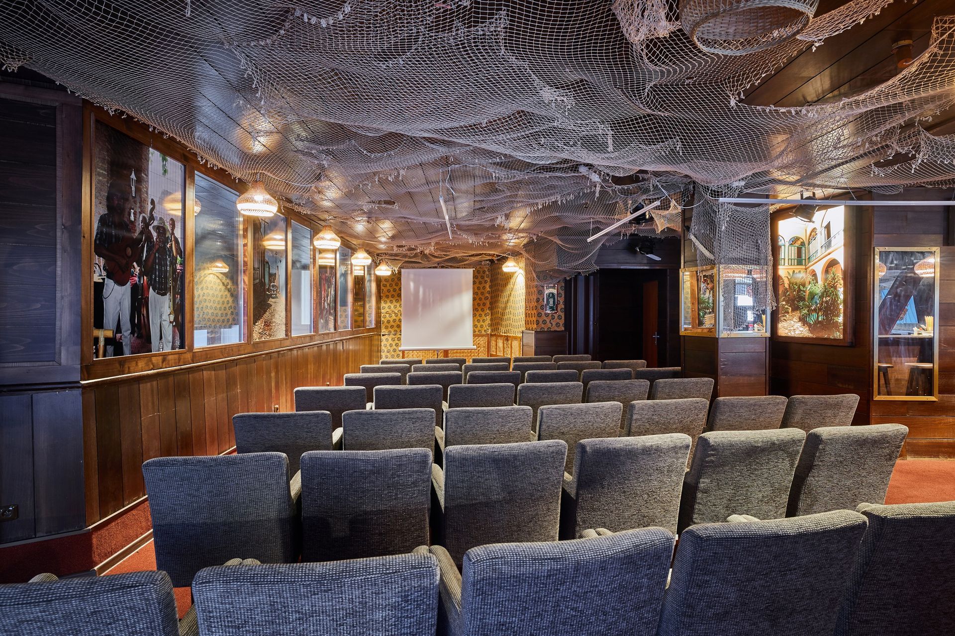 Velké hlediště s řadami židlí a promítacím plátnem.