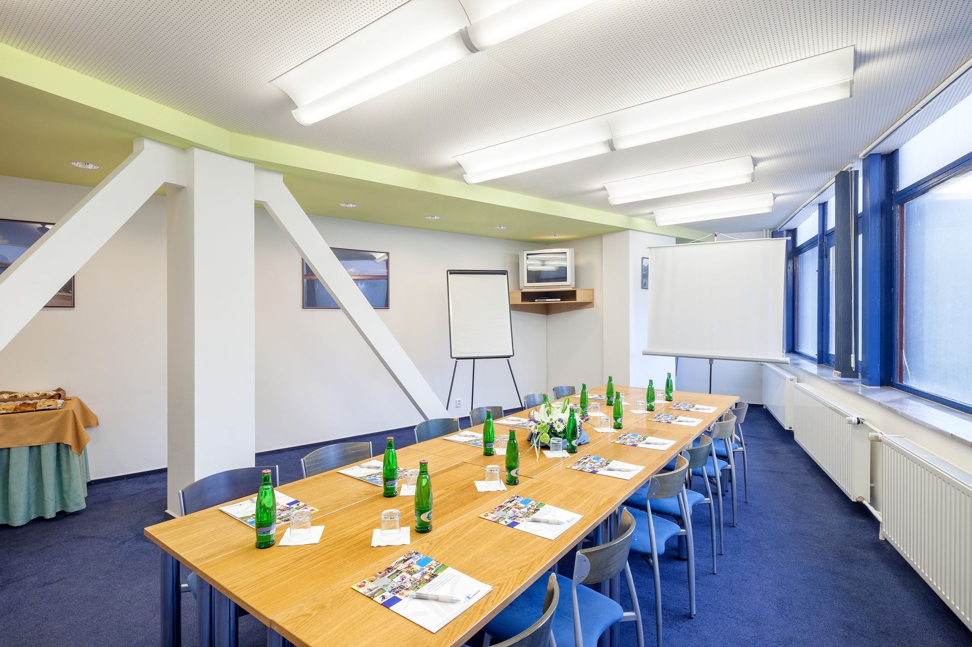 Konferenční místnost s dlouhým stolem a židlemi