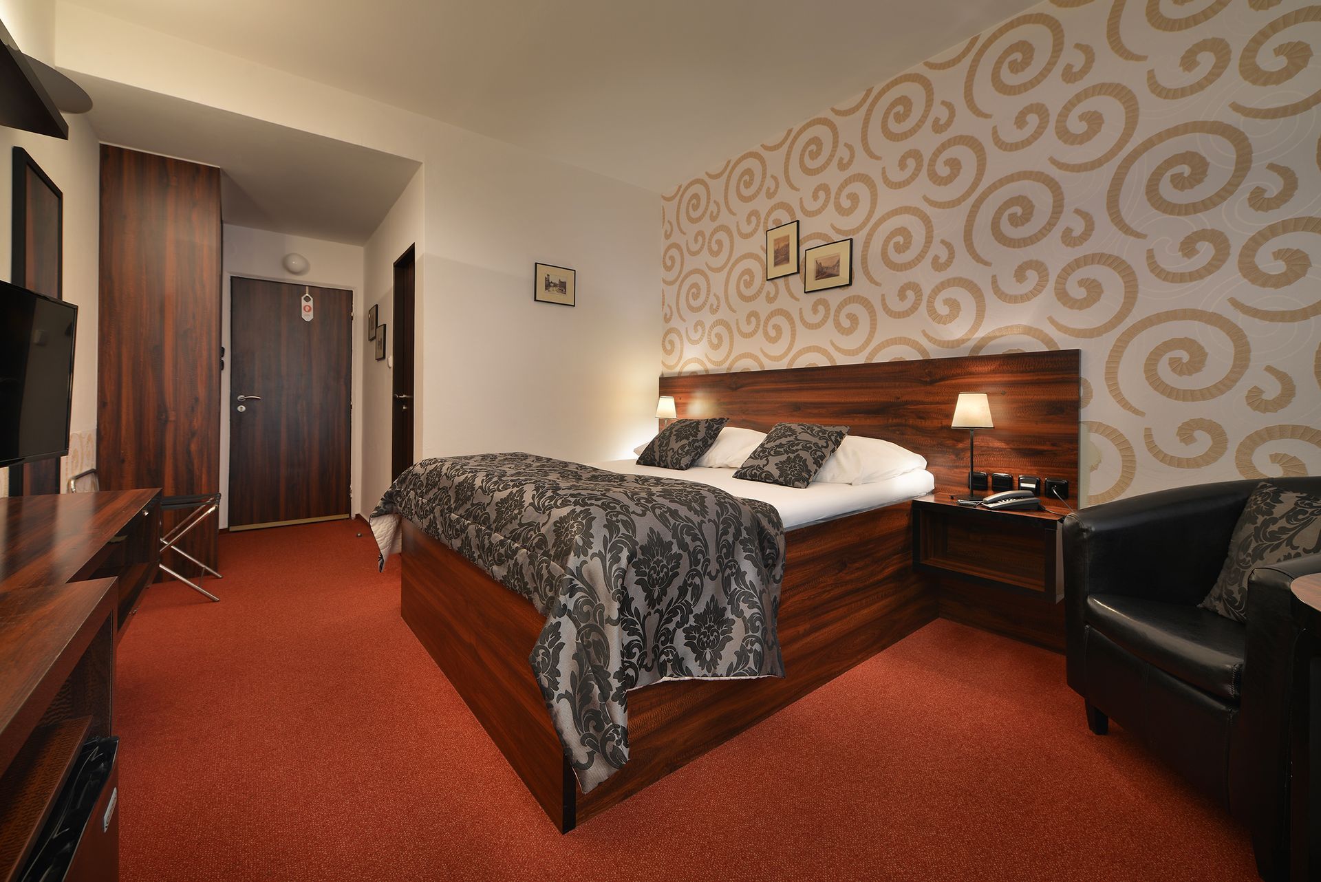 Hotelový pokoj s manželskou postelí velikosti King a židlí