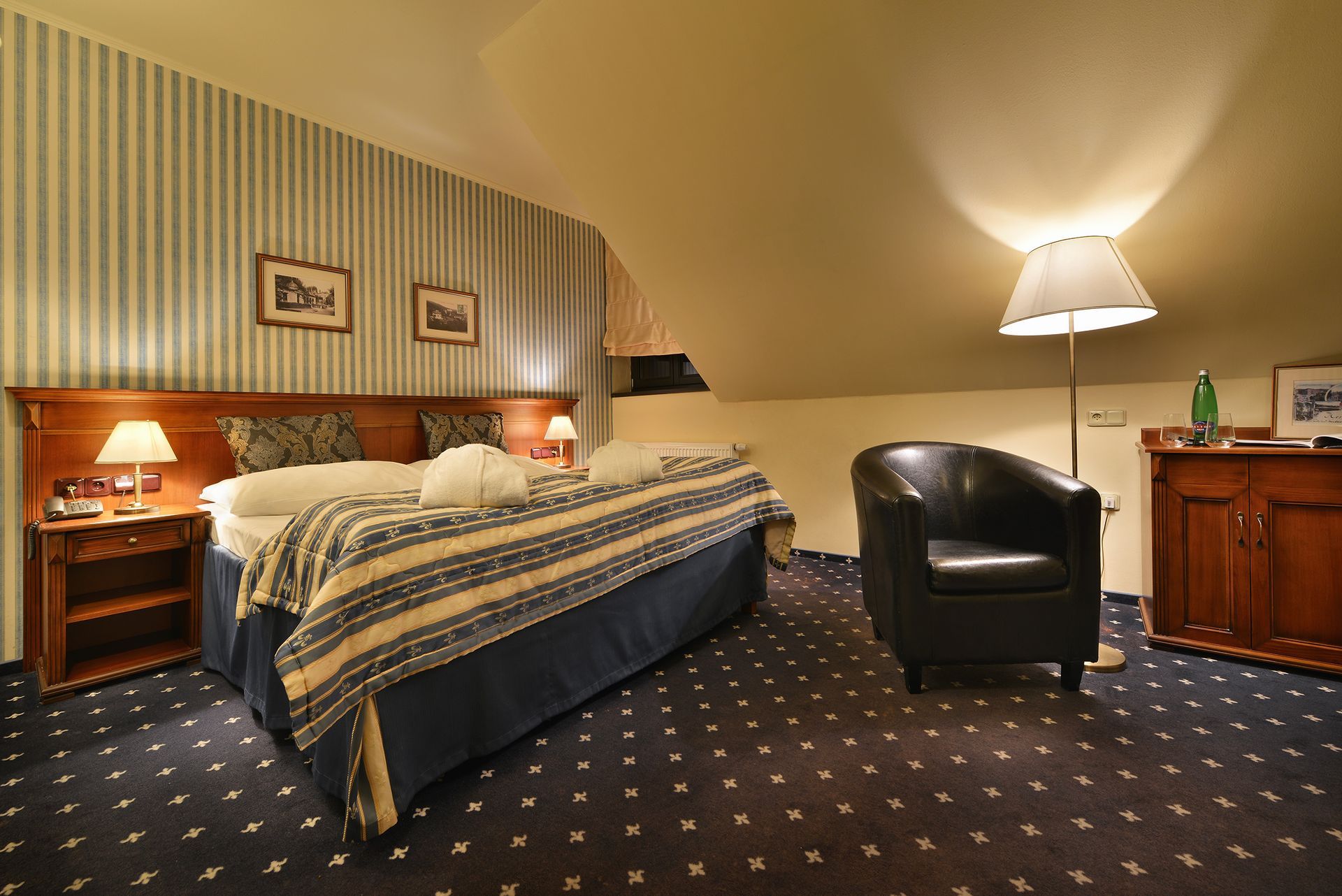 Hotelový pokoj s velkou postelí a židlí