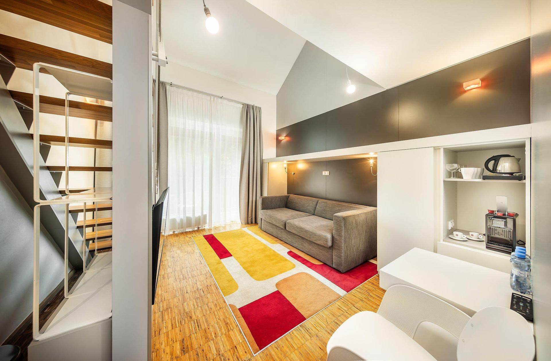 Obývací pokoj s pohovkou, židlí, stolem a schody.