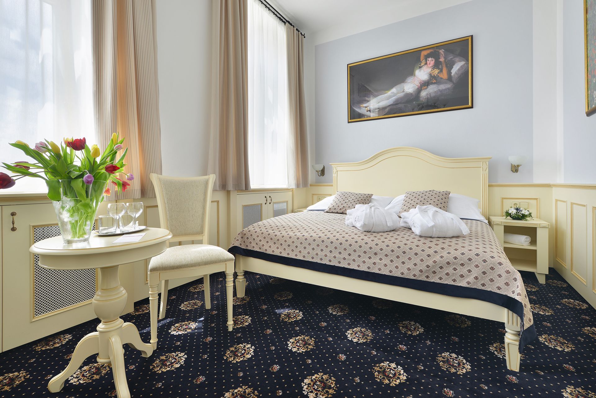 Hotelový pokoj s velkou postelí a TV s plochou obrazovkou.