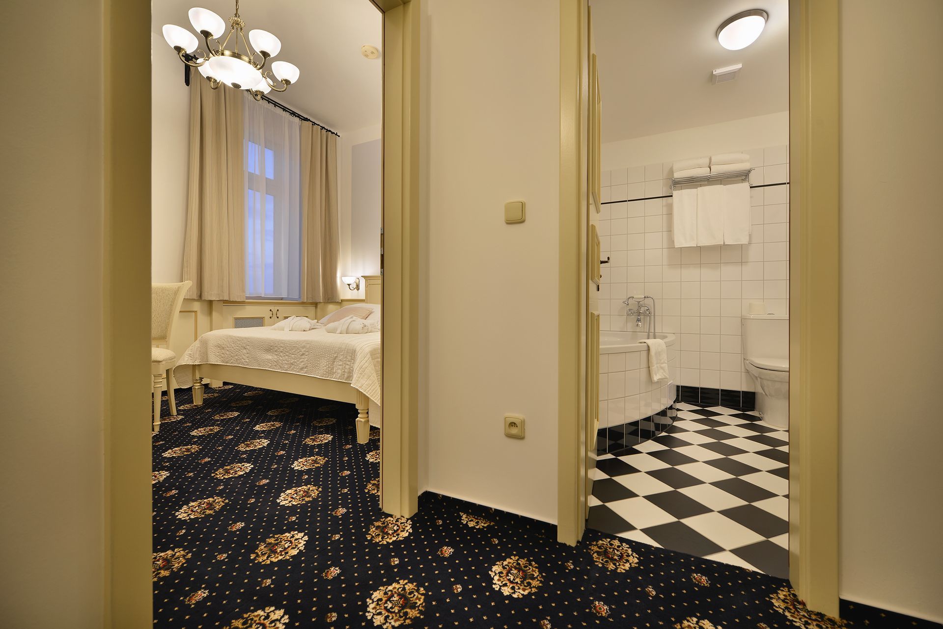 Hotelový pokoj s gaučem , stolem , televizí a postelí.