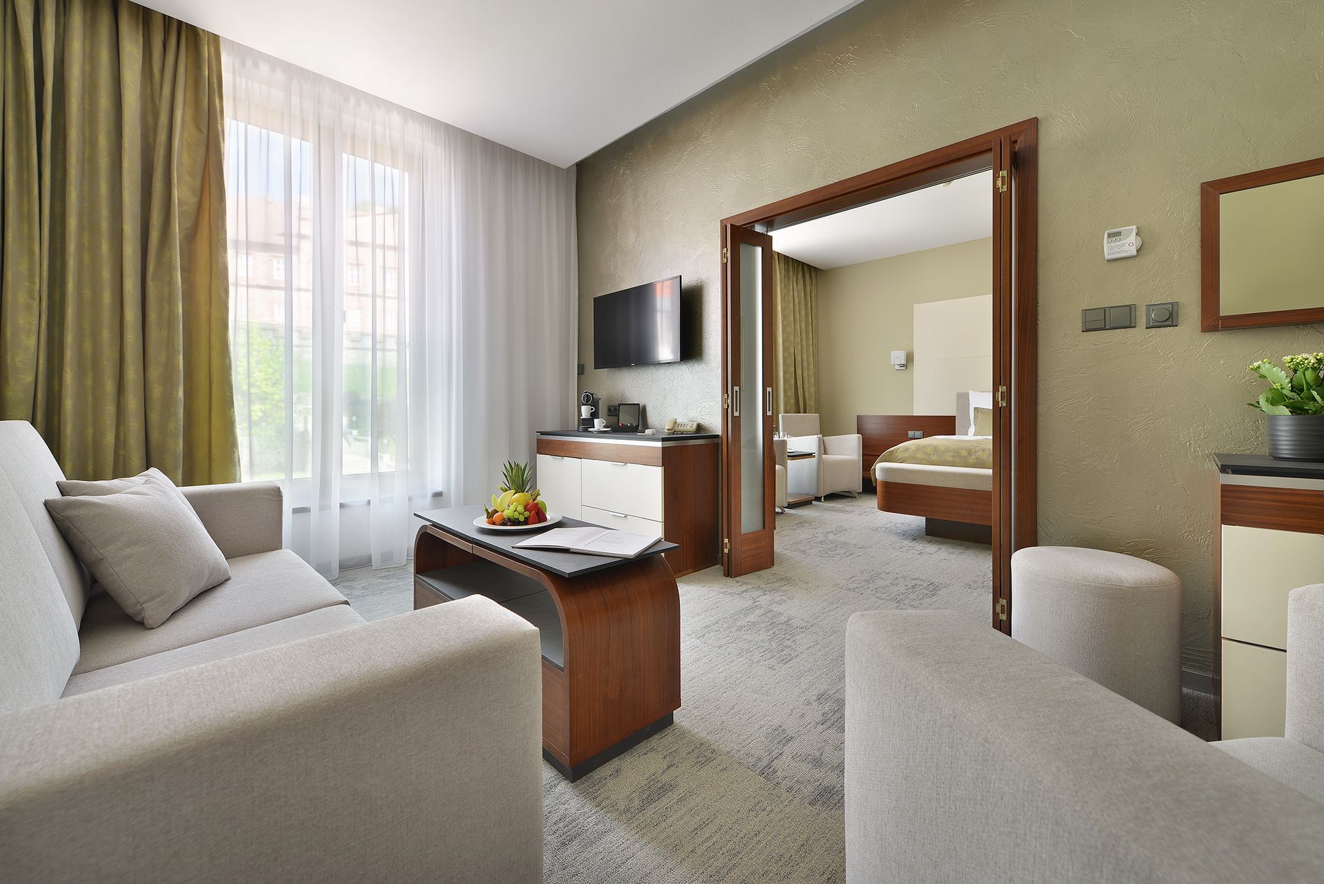 Hotelový pokoj s velkou postelí a TV s plochou obrazovkou.