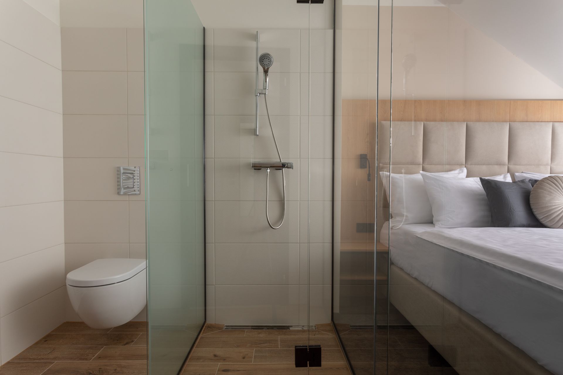 Ložnice se sprchovým koutem, toaletou a postelí.