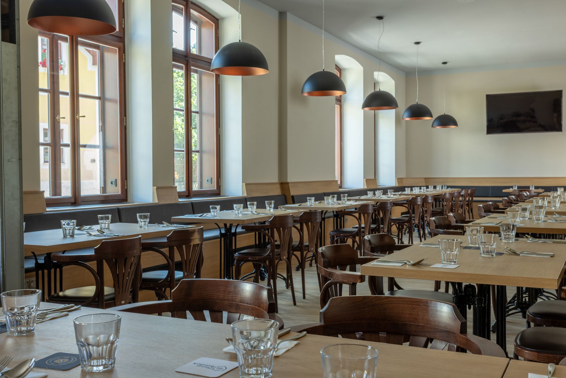 Restaurace se stoly, židlemi a sklenicemi na nich