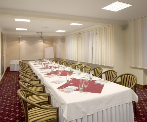 Konferenční místnost s dlouhým stolem a židlemi