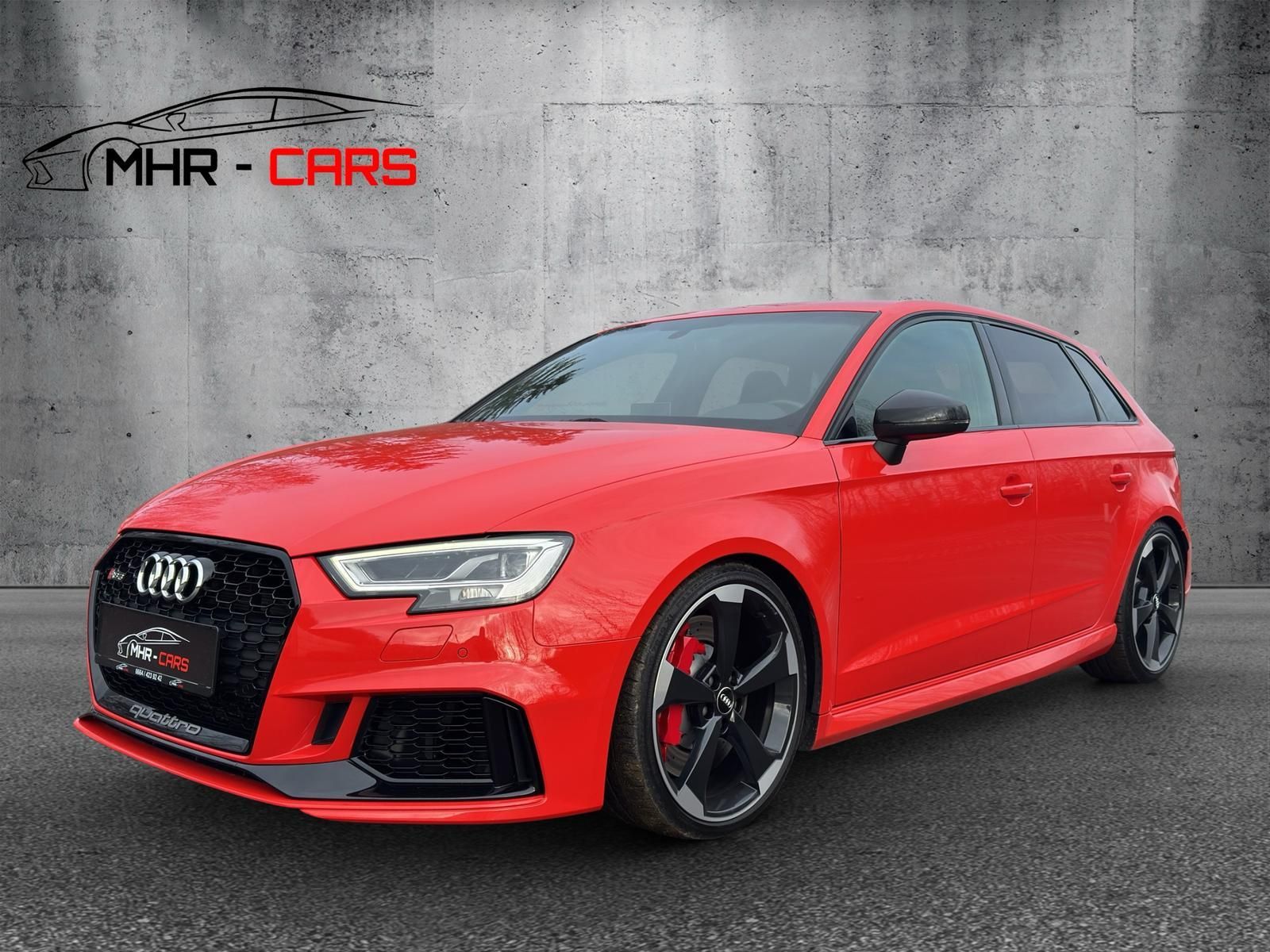 Ein roter Audi A3 RS parkt vor einer Betonmauer.