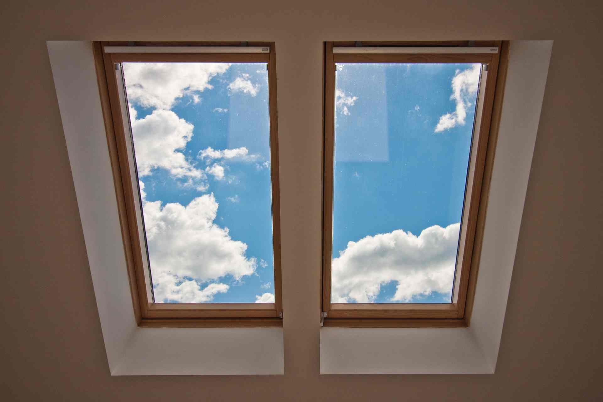 Skylight window, without window treatments, with a view of a blue sky with some fluffy clouds at Exc