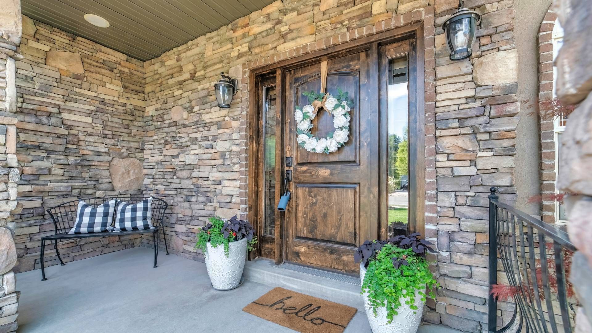 A modern home with farmhouse flair and sidelight windows adorning a rustic wood front door at Exciti