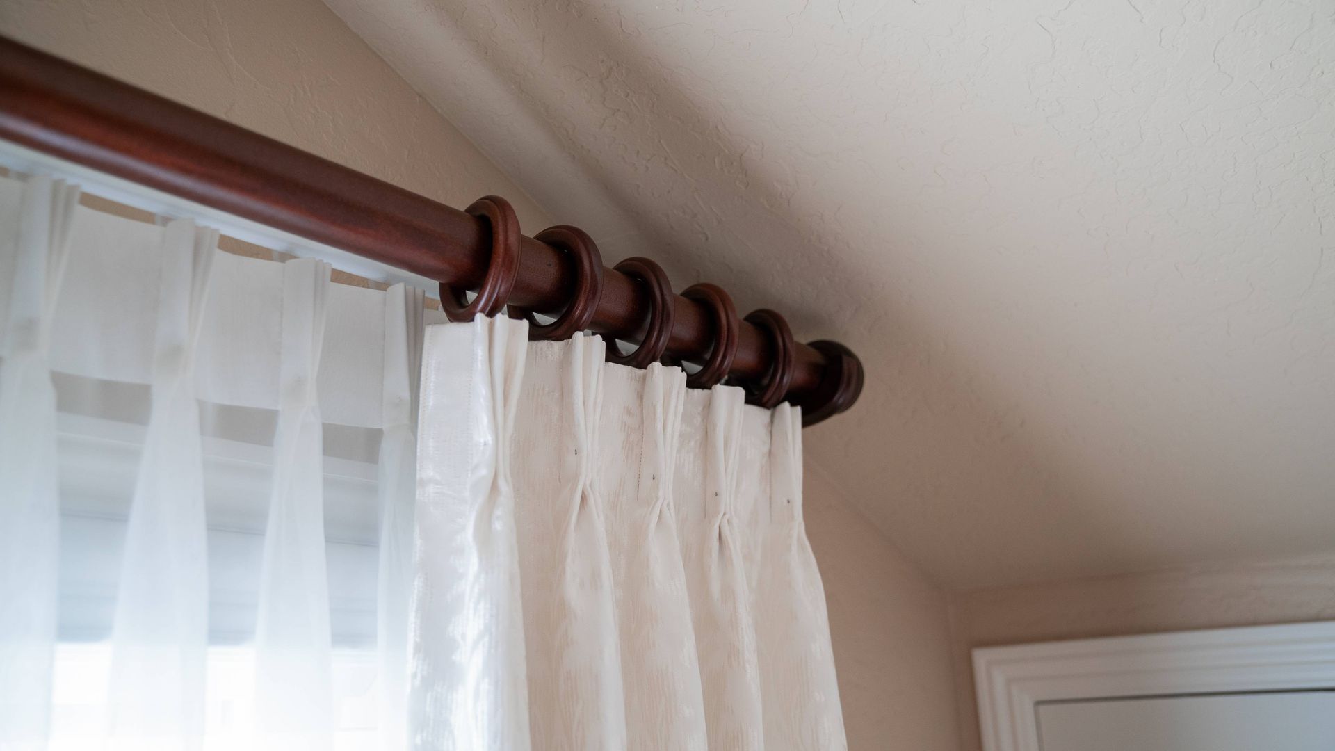 Drapery hardware featuring a rod and rings for custom drapes at a window