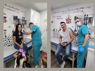 Two people receive vaccinations from a medical professional. Clinic setting with colorful wall art.