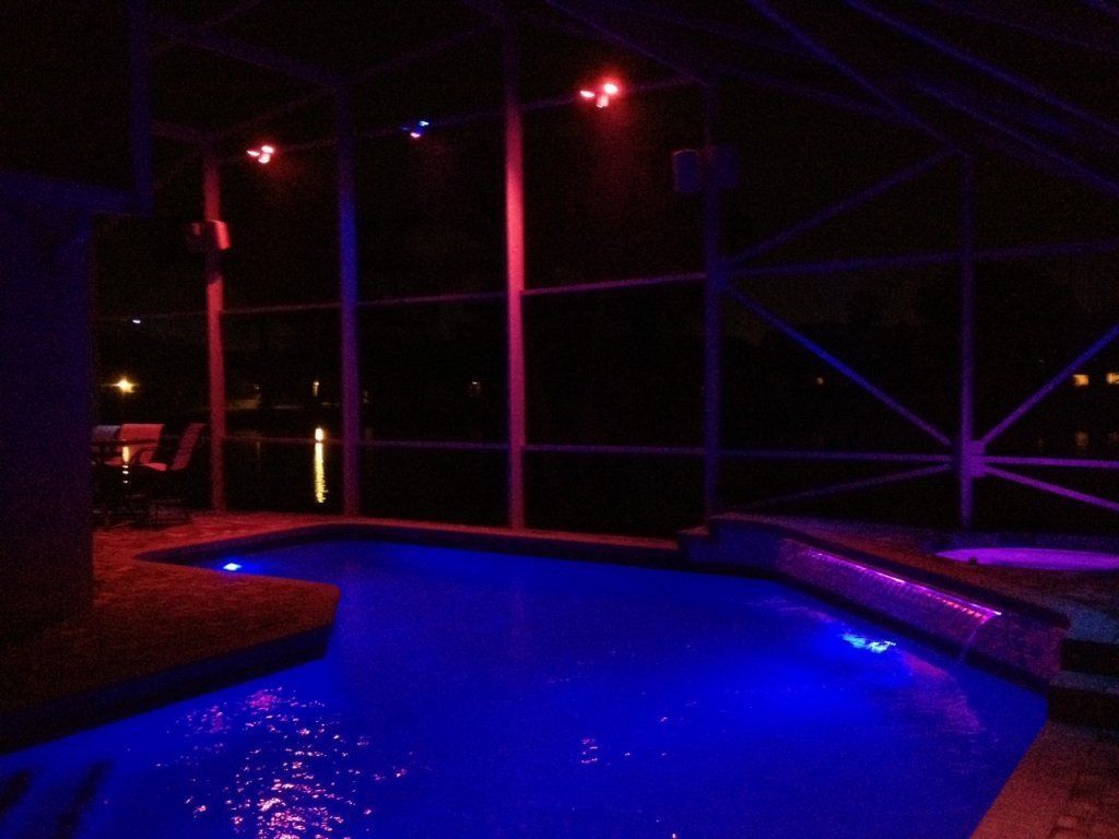 A swimming pool lit up with blue lights at night