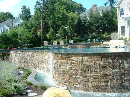 A swimming pool with a waterfall in the middle of it